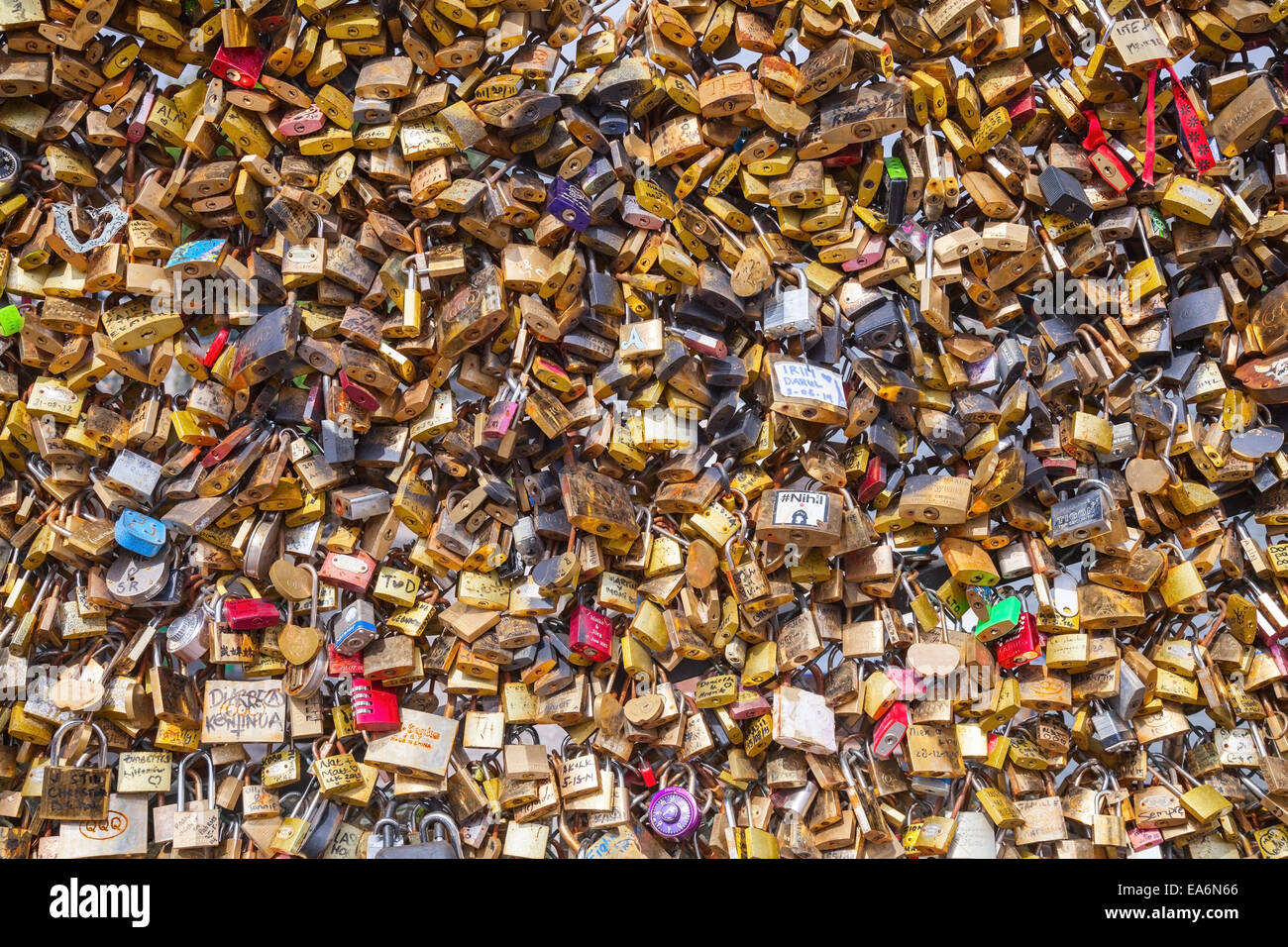 Paris, France - August 07, 2014: Padlocks with names hanging on railing of Pont des Arts over the river Seine. A lot of locks of Stock Photo