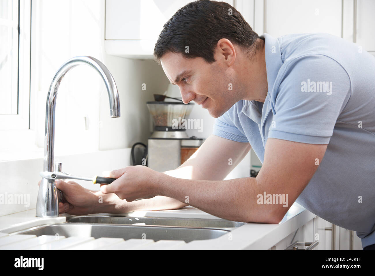 Plumber Mending Tap With Adjustable Wrench Stock Photo