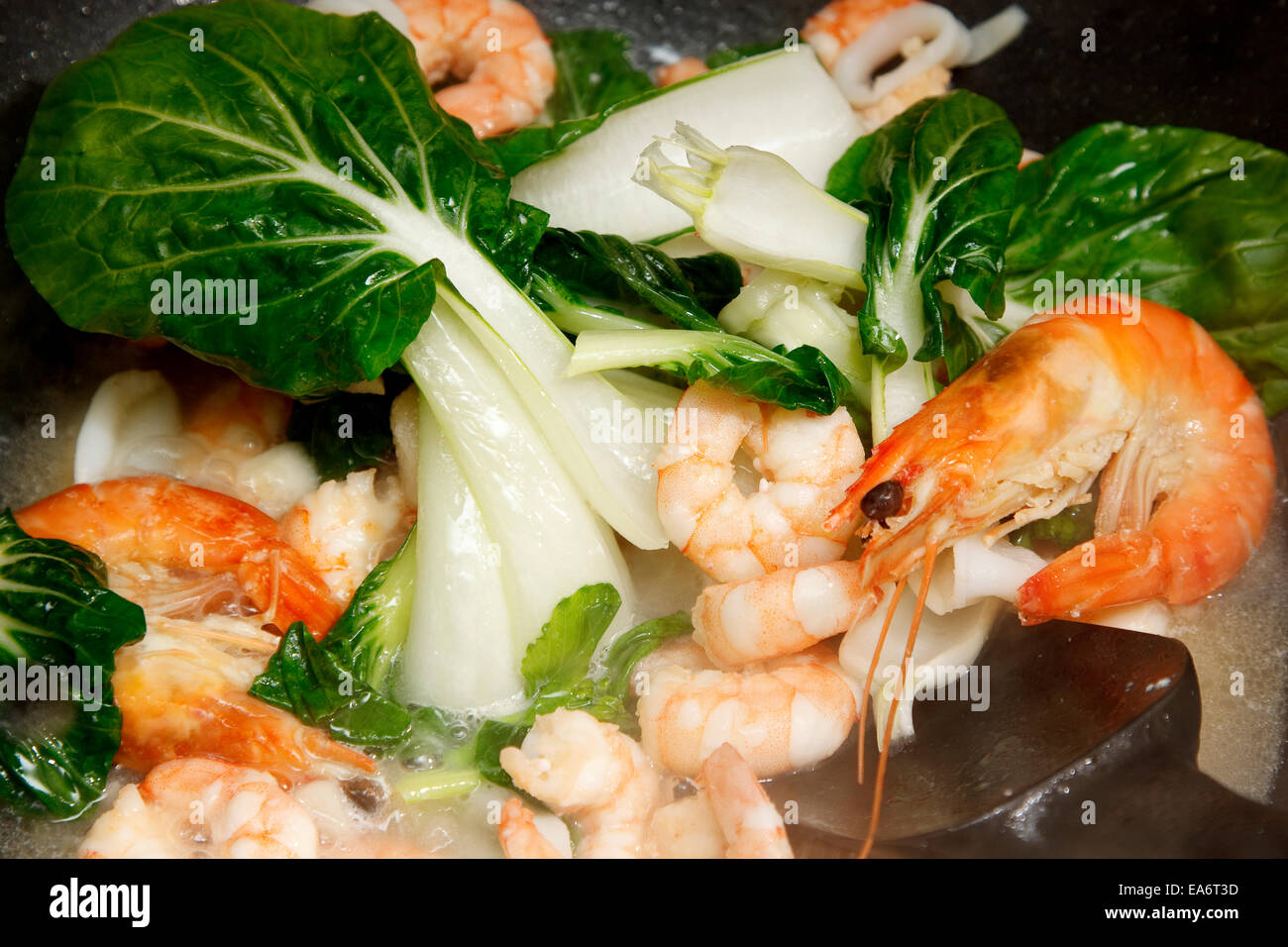 Prawns with  pak choi cooking in a wok Stock Photo