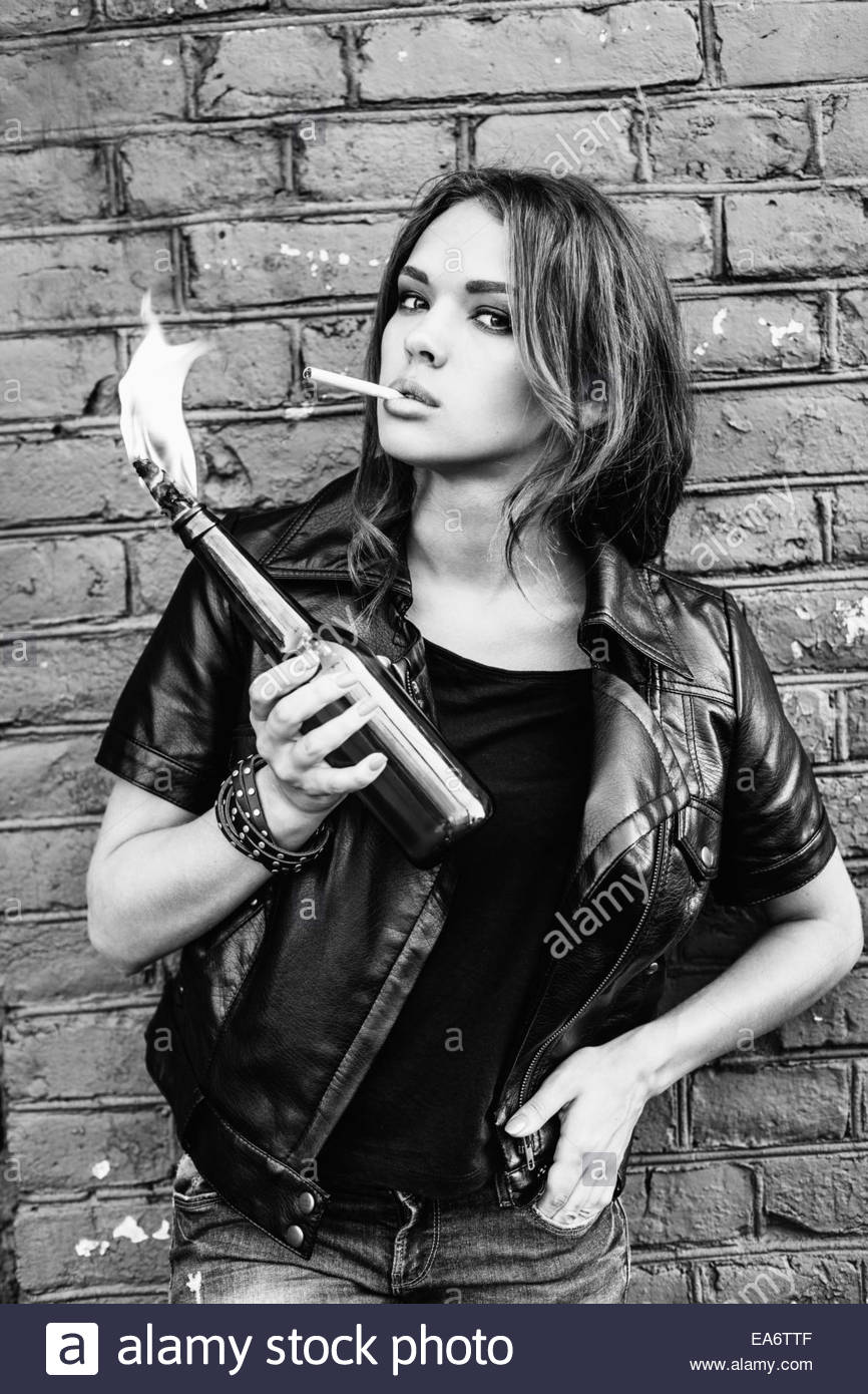Black and white portrait of a beautiful girl smoking with a molotov cocktail in her hand