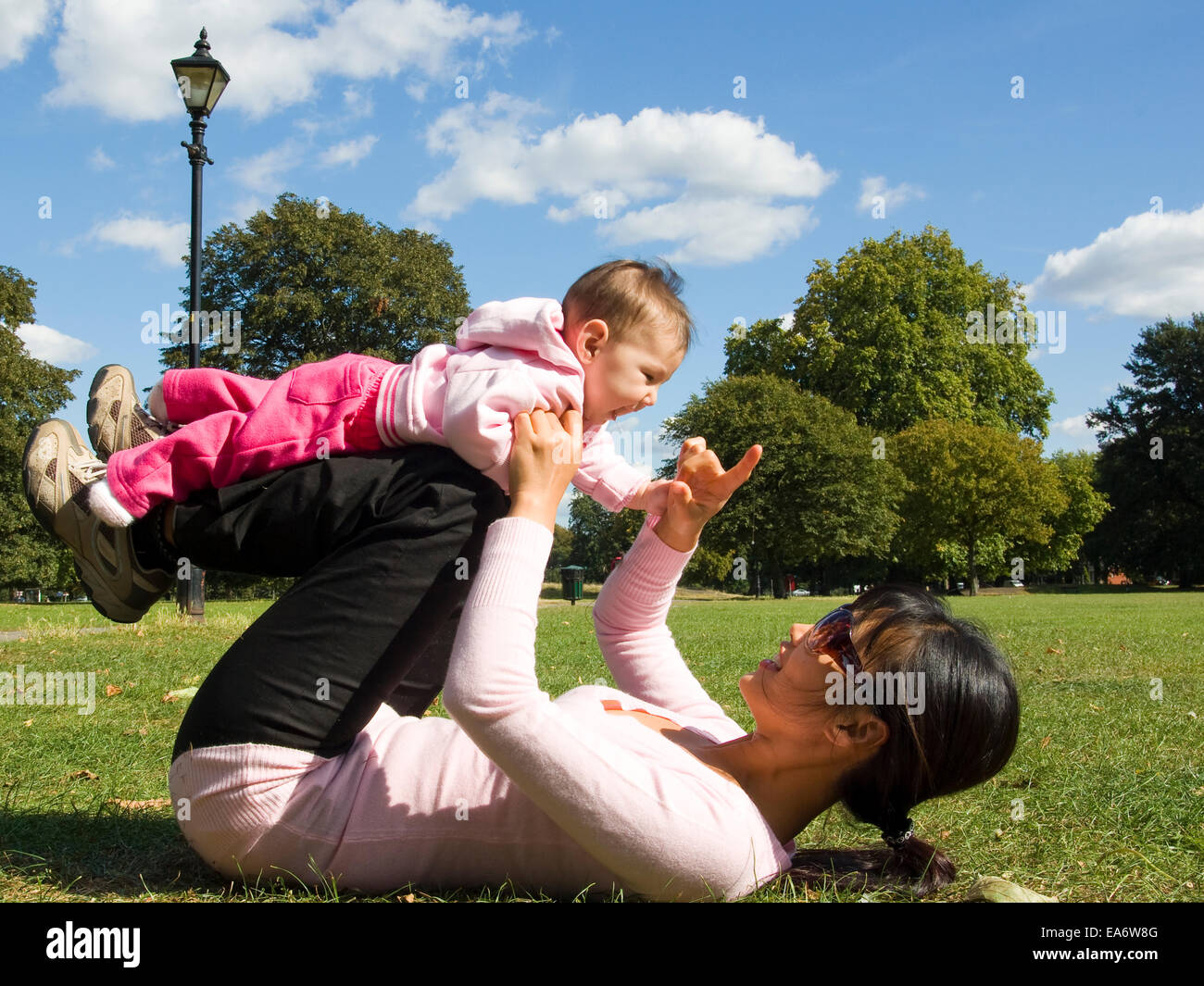 young Korean mother and mixed race (asian / caucasian) baby girl  playing in park Stock Photo