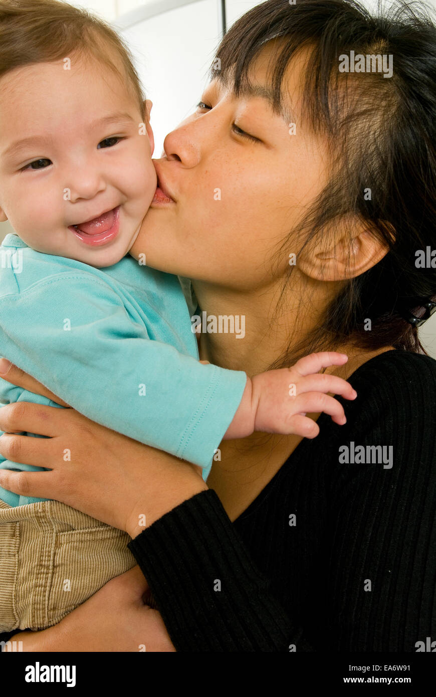 young Korean mother kissing mixed race (asian / caucasian) baby girl