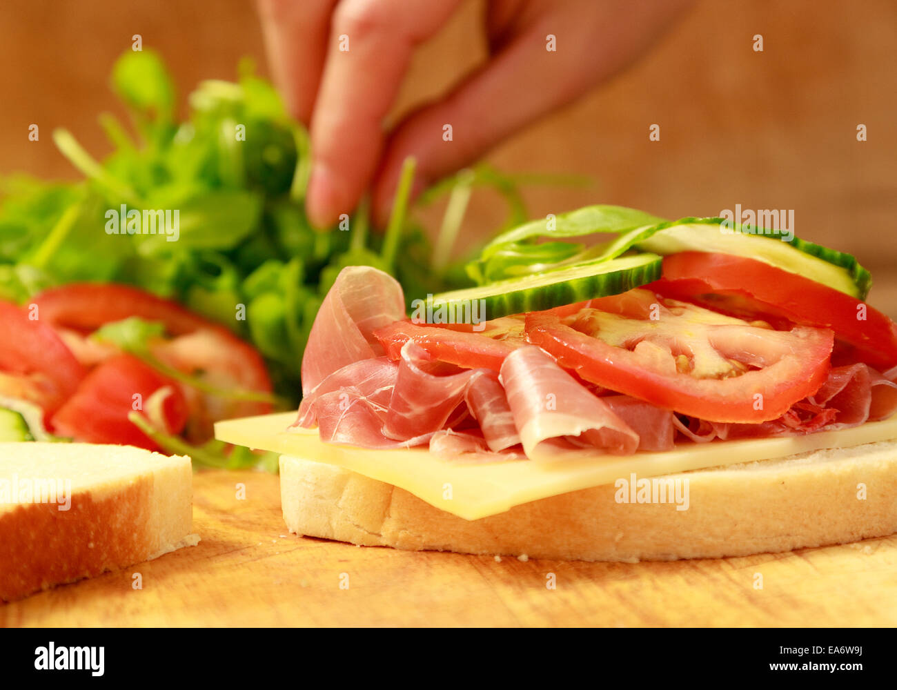 white bloomer bread sandwich of prosciutto ham, Gruyere cheese, sliced tomato and rocket Stock Photo