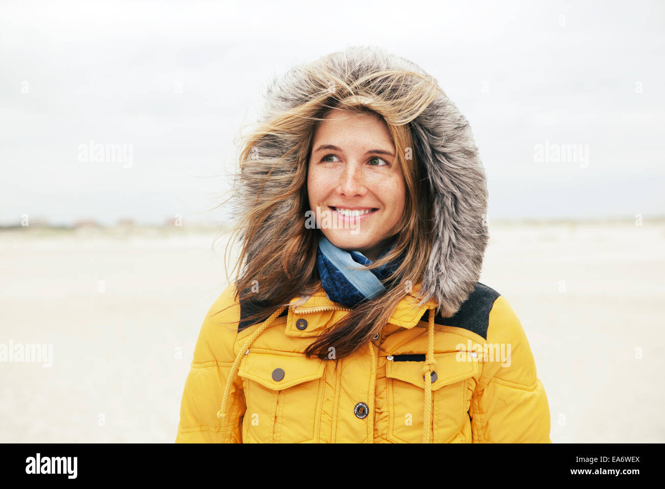 young woman with hat in winter on the beach, the hair will be gone with the wind Stock Photo