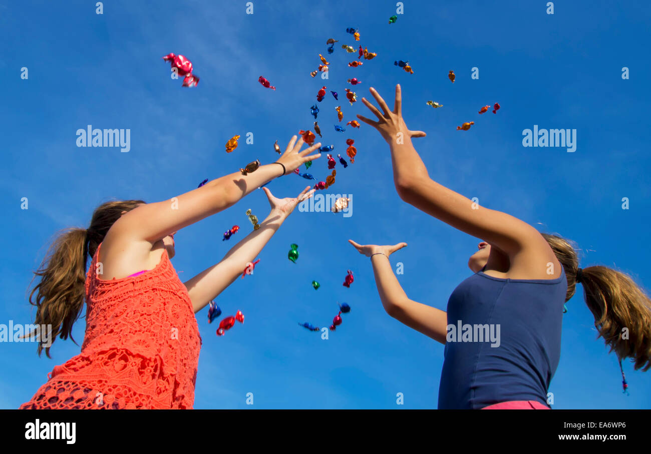 Teenage girls throw sweets in air; United Kingdom Stock Photo