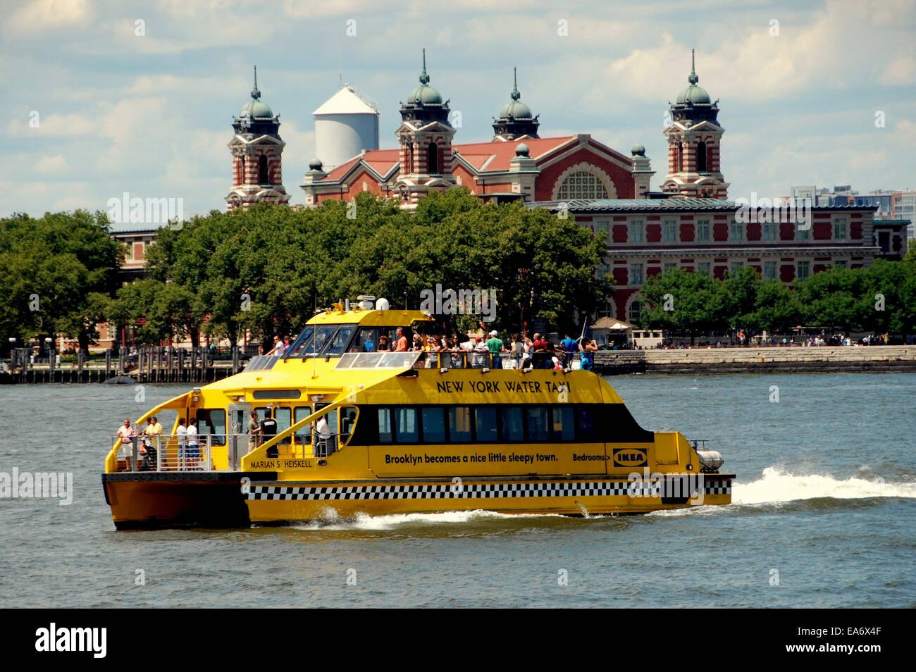 NYC A New York Water Taxi on the Hudson River passing by Ellis Island