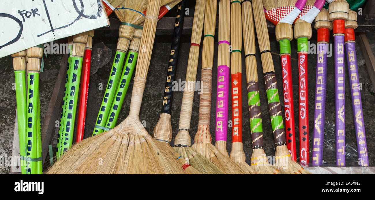 Colorful handmade souvenir straw fan brooms for sale at a roadside stand in the Philippines. Stock Photo