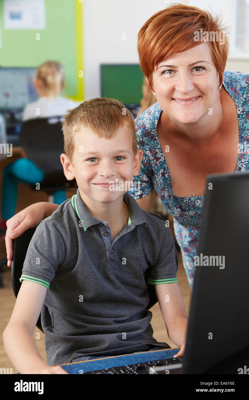 Male Elementary Pupil In Computer Class With Teacher Stock Photo - Alamy