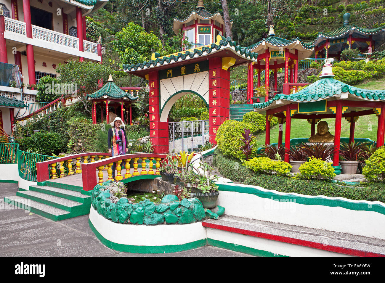 A tourist enjoys the Bell Church, a Taoist Temple, beautiful grounds with pagodas, gardens in Baguio City, Philippine Islands. Stock Photo