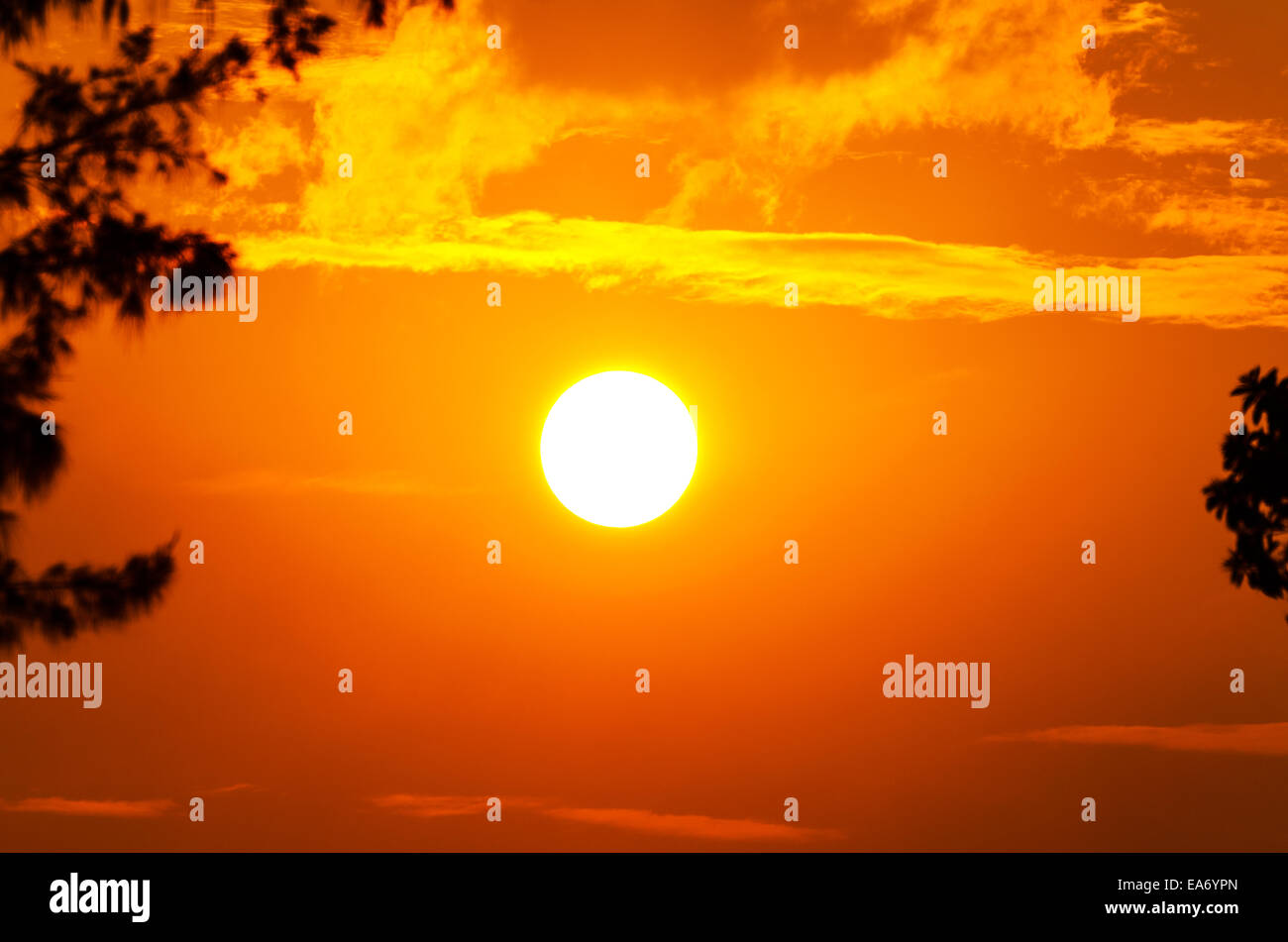 Sun and cloud in sky with a bright orange glow at sunset Stock Photo ...