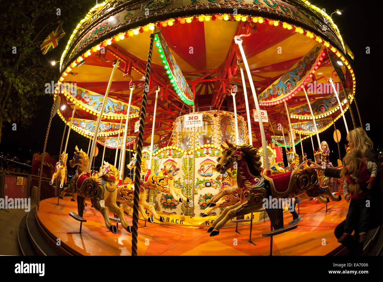 Merry-go-round on the riverside promenade after dark, South Bank, London Stock Photo