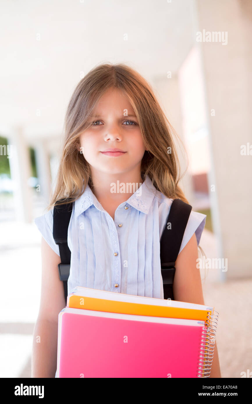 Little cute girl holding books at school Stock Photo - Alamy