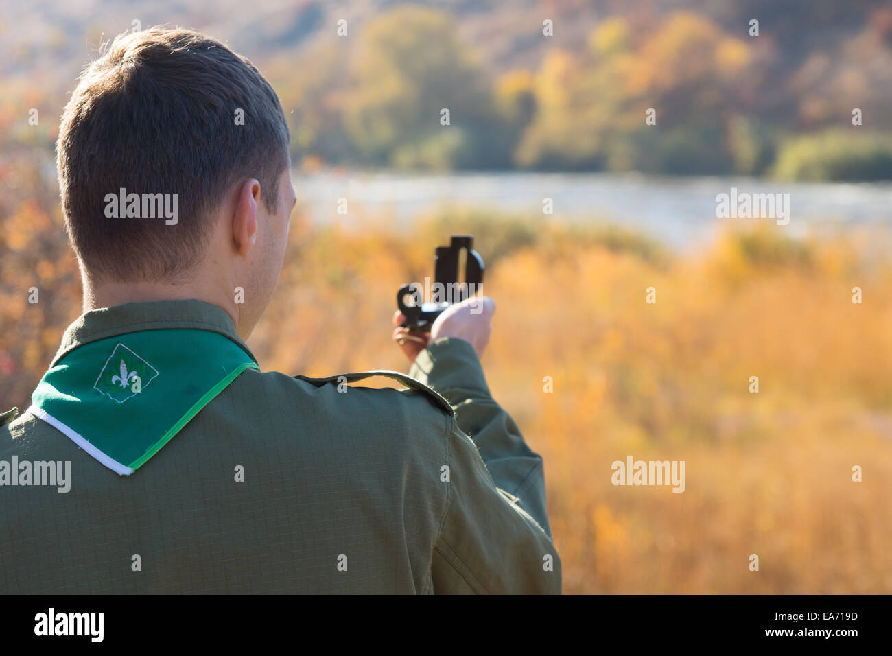 View from behind over the shoulder of a scout taking a reading with a ...
