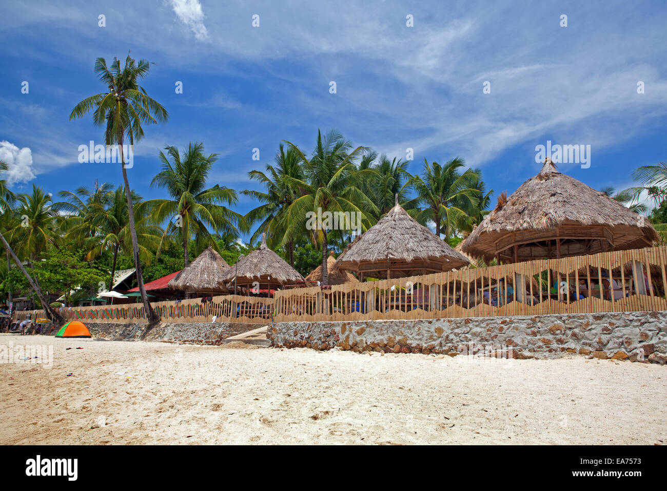 Thatch roof beach huts line the shore of Alubihod at Raymen Beach Resort on Guimaras Island, Philippines. Stock Photo