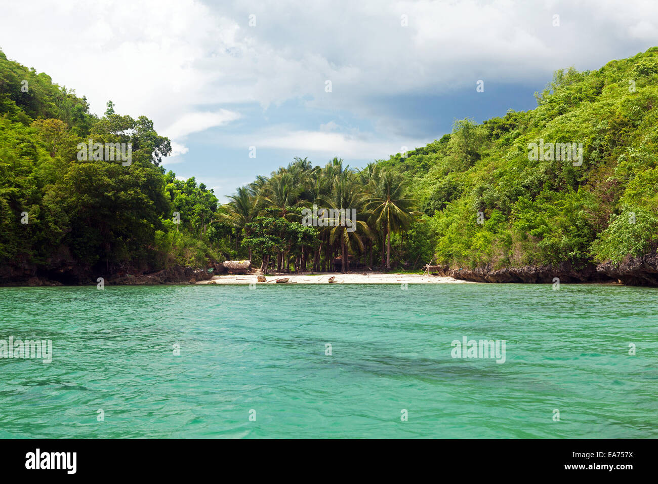 A Filipino tourist boat approaches one of hundreds of remote island beaches in the Guimaras Islands in the Philippines. Stock Photo