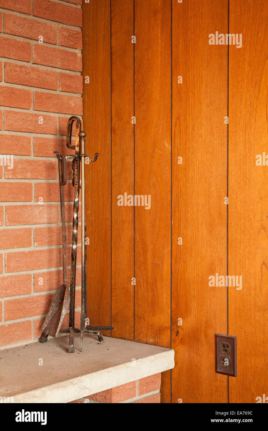 A Fireplace Toolset Sitting On A Hearth With Retro Decor Near