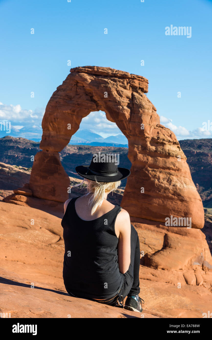 A female tourist enjoying the view at the Delicate Arch. The Arches National Park, Utah, USA. Stock Photo