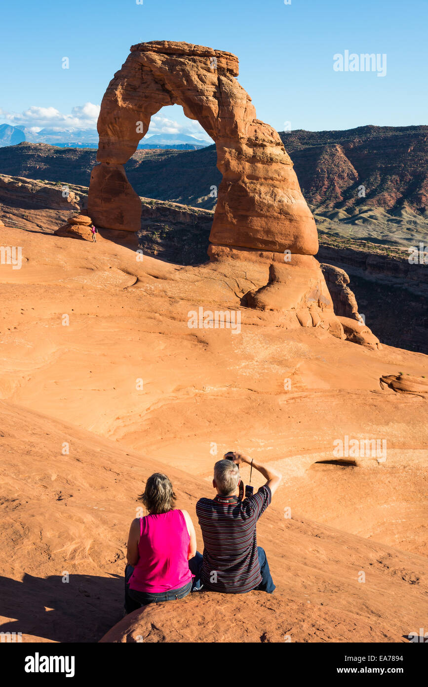 A couple taking pictures of the Delicate Arch. The Arches National Park, Utah, USA. Stock Photo