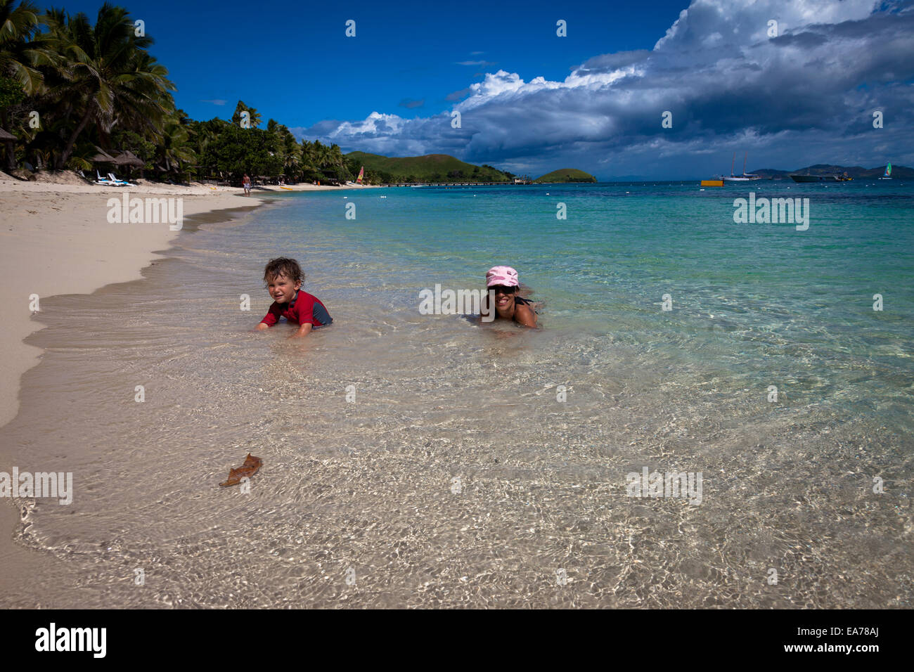 Tropical Vacation - Mother and son relaxing in the clear beautiful Ocean Stock Photo