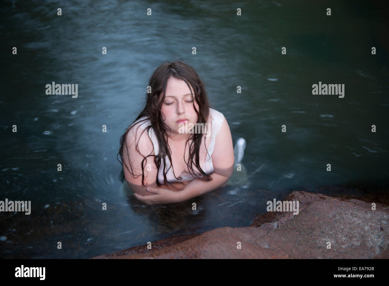 Portrait of pre-teen girl (10-12) with wet hair half-submerged in river waters Stock Photo