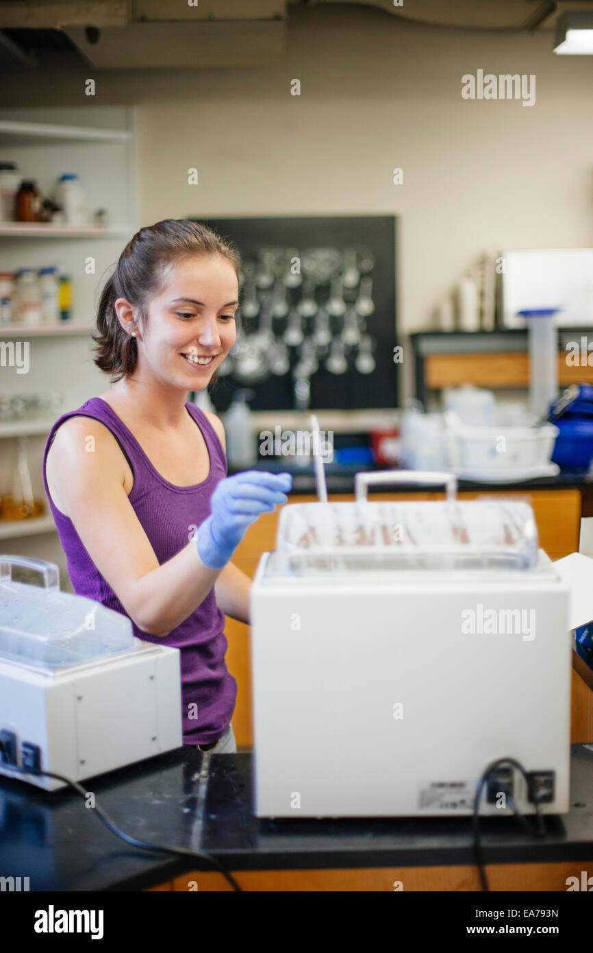 Portrait of smiling young adult woman working in laboratory Stock Photo