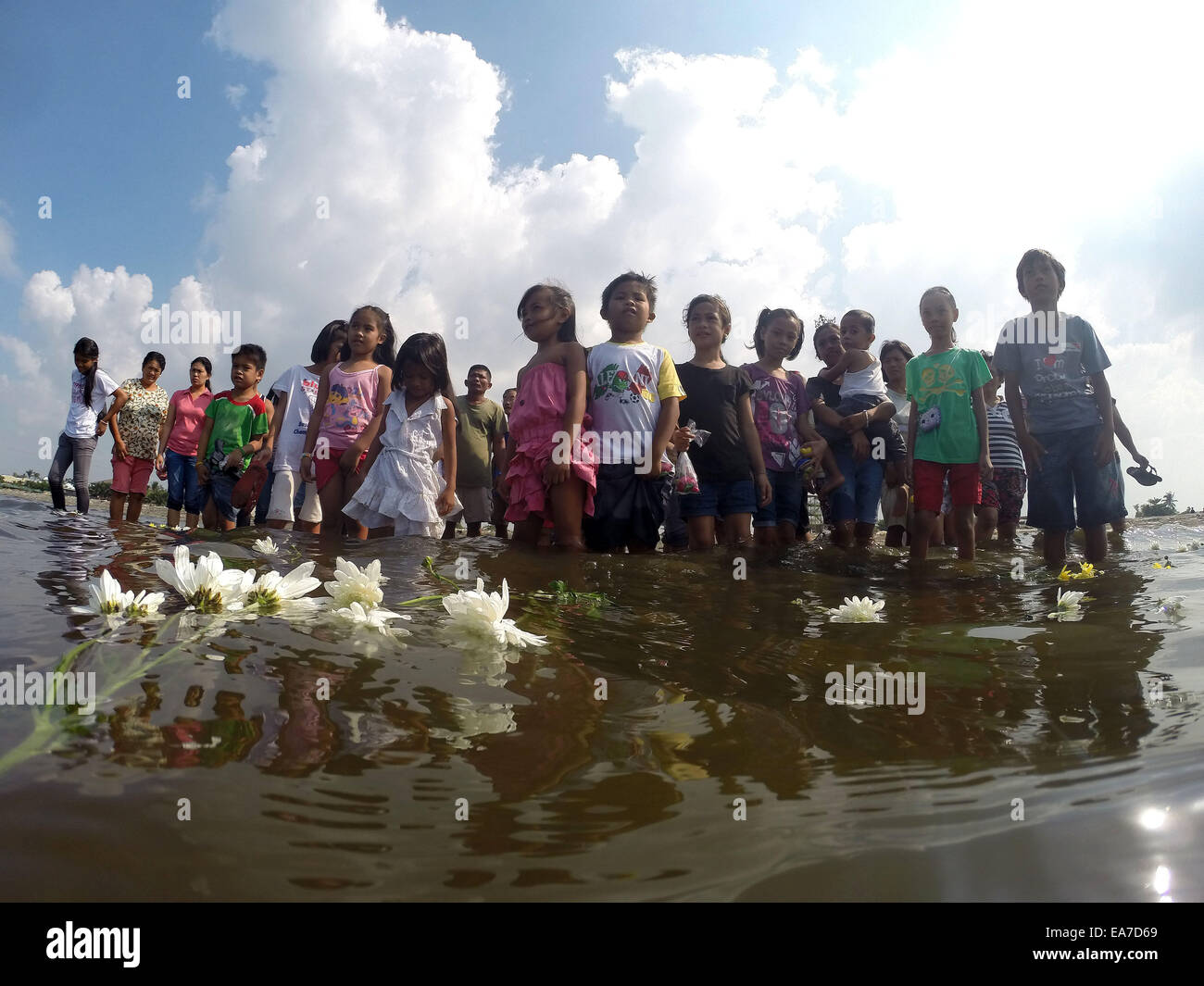 Rizal Province, Philippines. 8th Nov, 2014. Survivors of super typhoon Haiyan put flowers into the sea as they commemorate the first anniversary of typhoon Haiyan in Rizal Province, the Philippines, Nov. 8, 2014. The Philippine government has completed the rehabilitation of three airports and 14 seaports in areas struck by typhoon Haiyan (local name Yolanda) to speed up recovery in those places, a senior government official said on Nov. 7. Credit:  Rouelle Umali/Xinhua/Alamy Live News Stock Photo