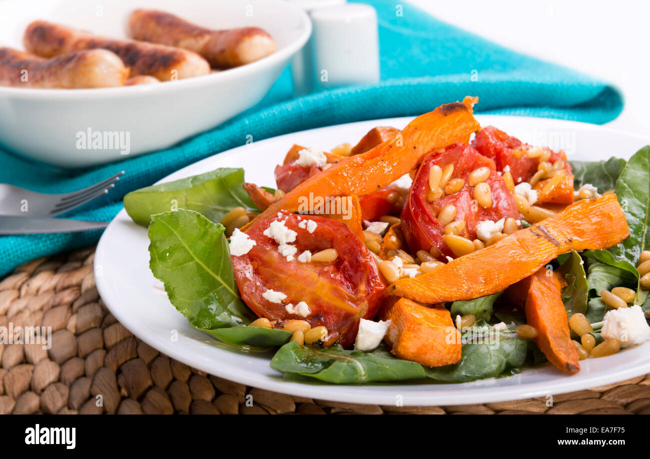 Roast pumpkin salad with tomatoes, pine nuts, feta and dressing Stock Photo