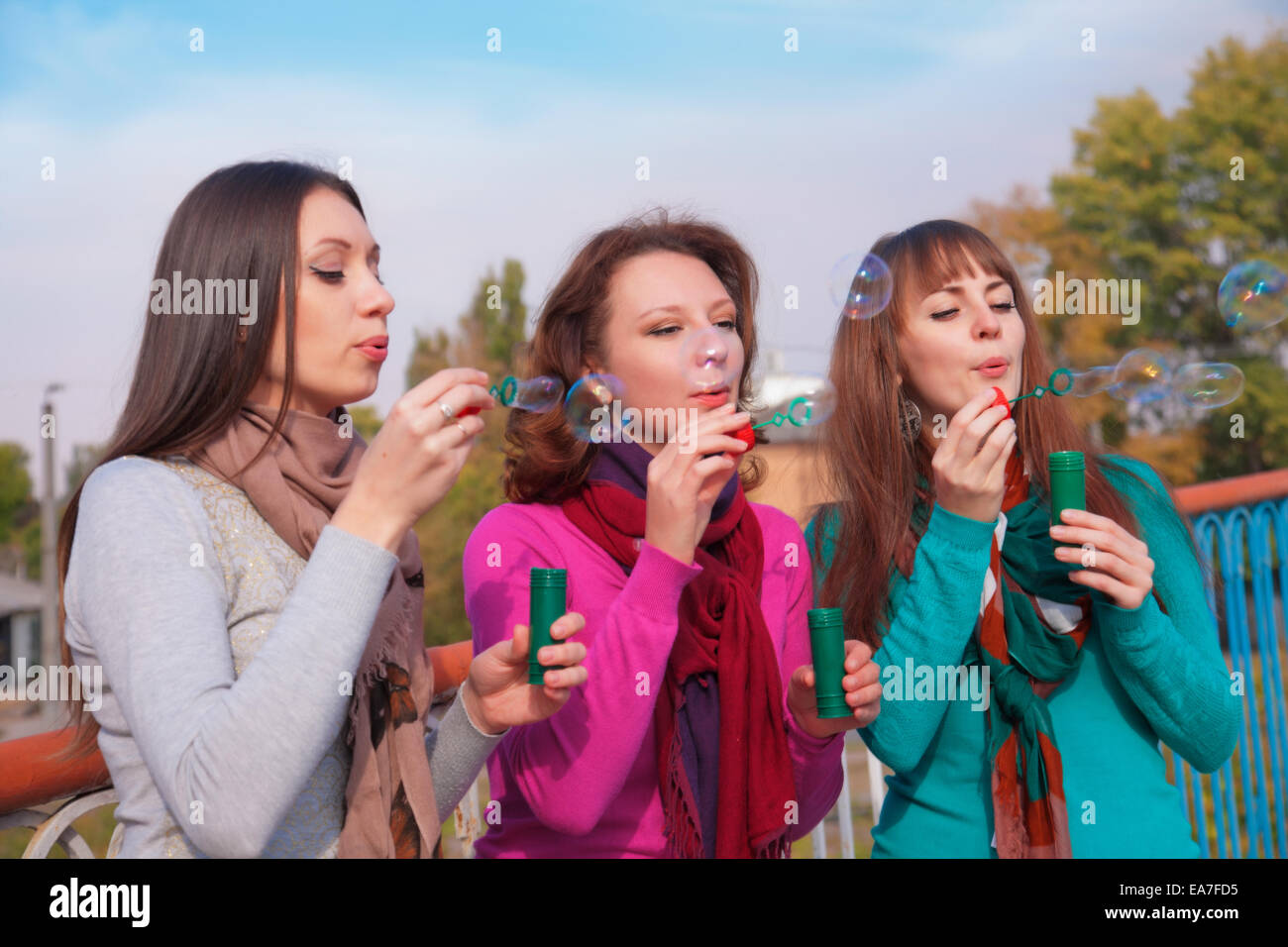 Three young beautiful women blow bubbles Stock Photo