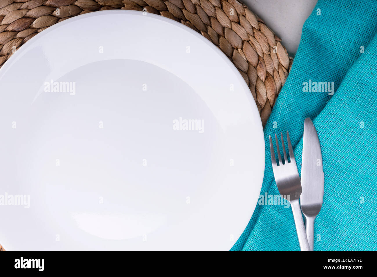 Round clean empty white plate on wooden mat Stock Photo