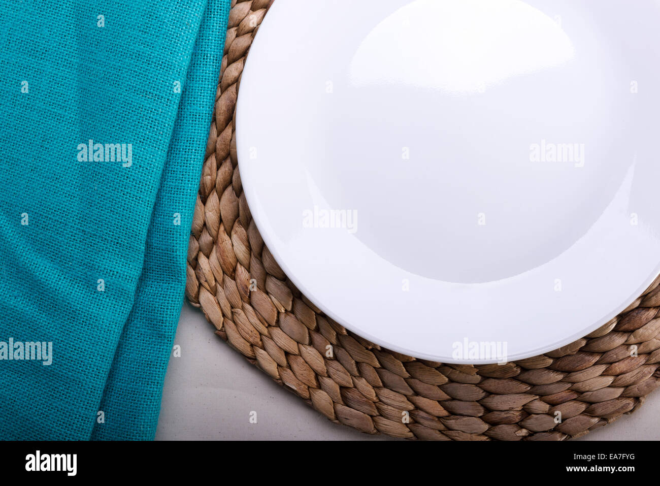 Round clean empty white plate on wooden mat Stock Photo