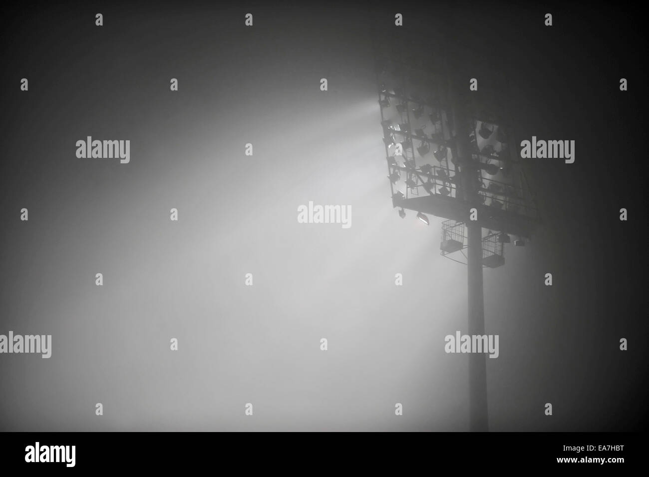 Football stadium floodlights are seen through dense fog in the night Stock Photo