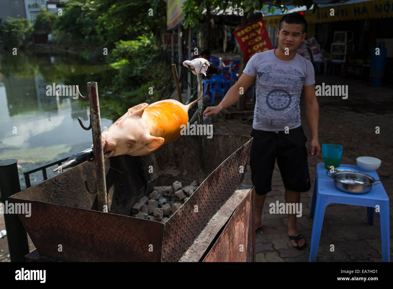 Man Roasts Pig on Road in Hanoi, Vietnam Stock Photo