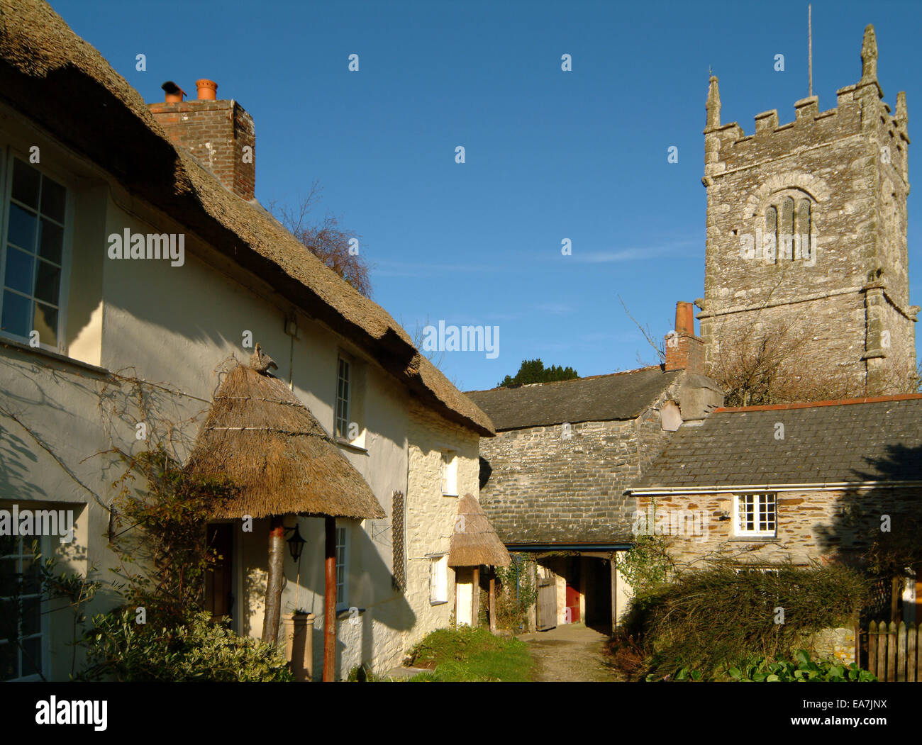 Row of thatched cottages & church tower at St Clement near Malpas Truro
