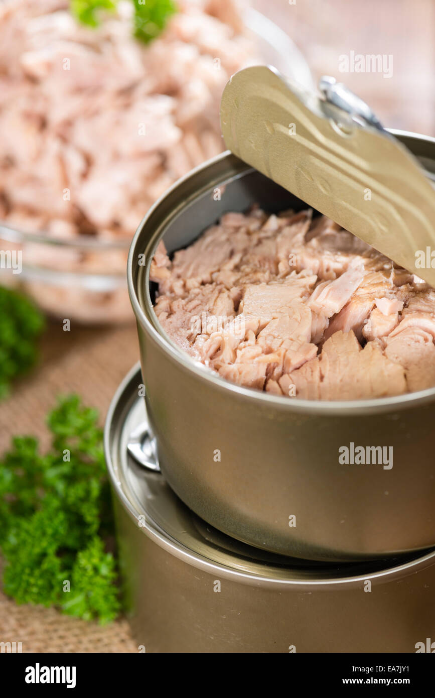 Canned tuna with fresh parsley (detailed close-up shot) on wooden background Stock Photo
