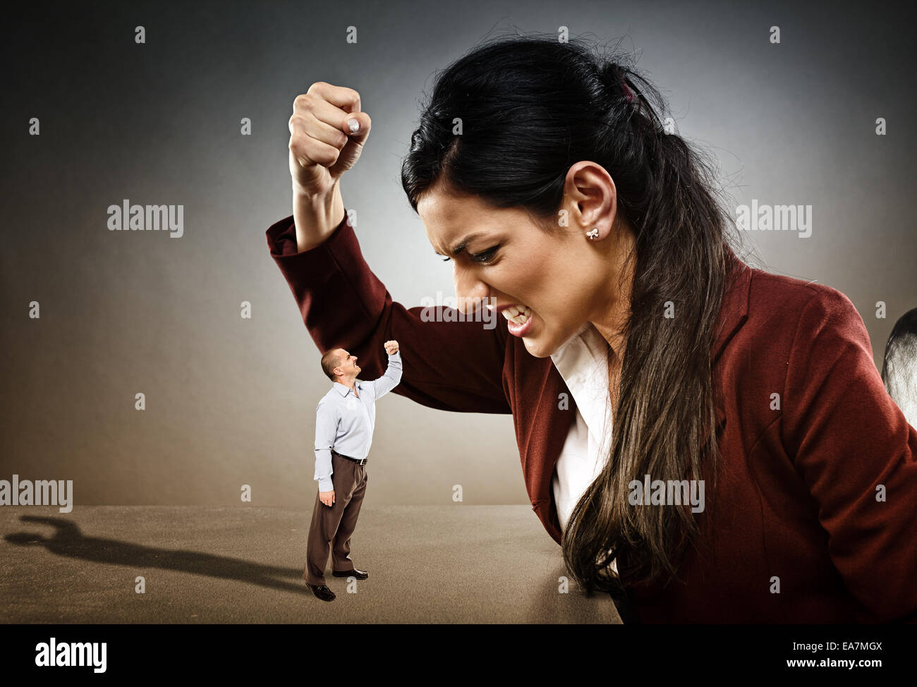 Angry businesswoman ready to crush the courageous subordinate who is confronting her Stock Photo