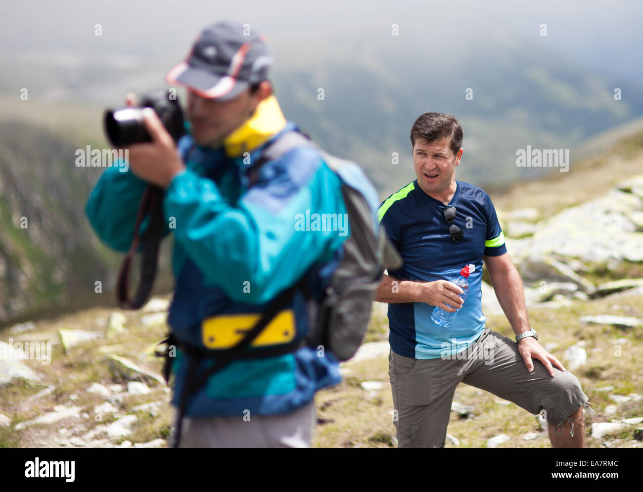 Two friends hiking together in mountains, with backpacks Stock Photo ...