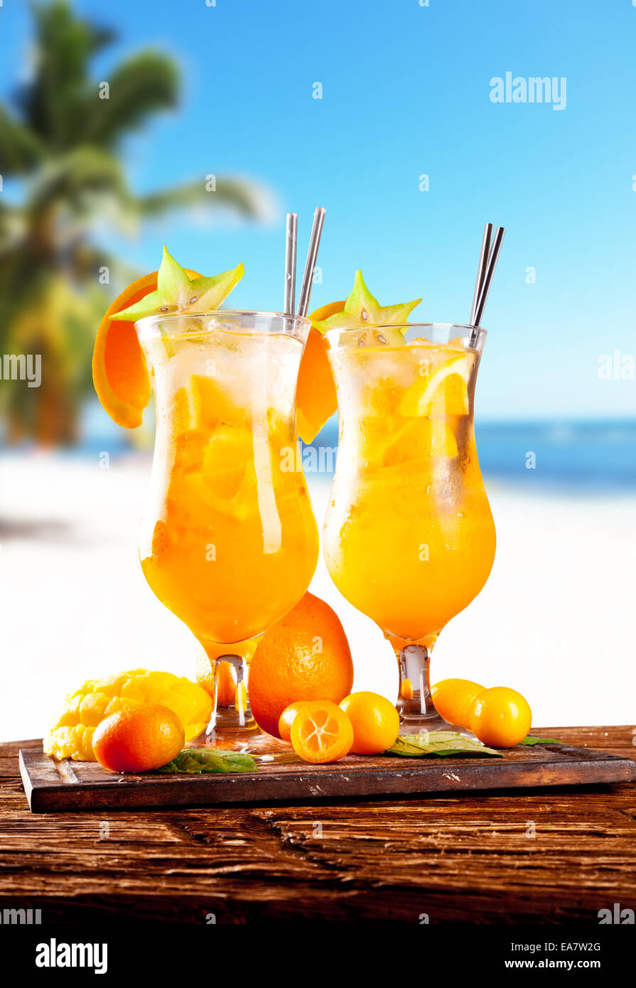 Fresh summer orange drinks, blur beach on background Stock Photo