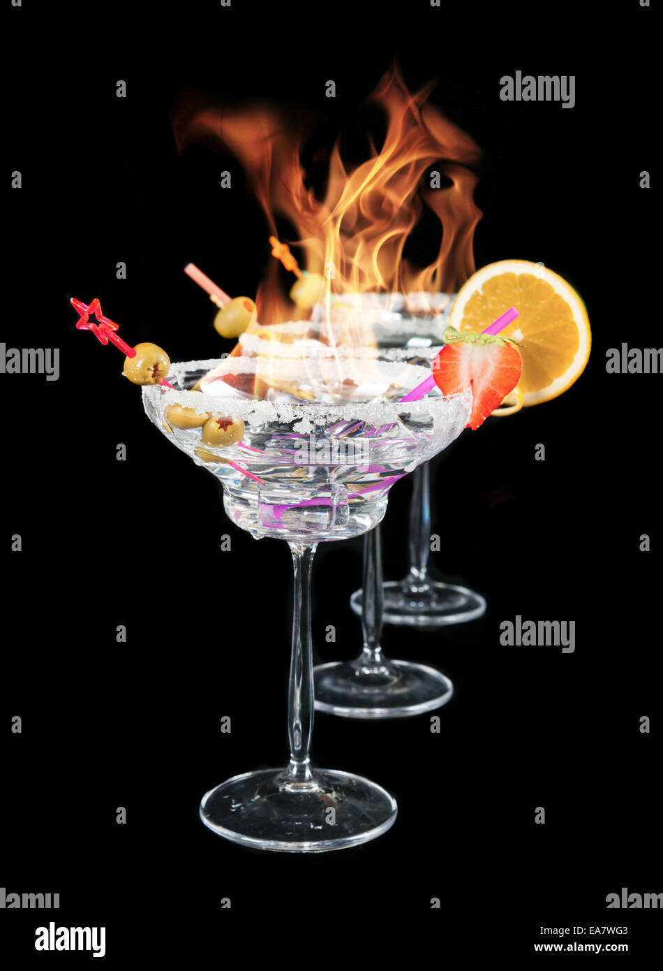 Glasses of alcohol cocktails burning on top, isolated on black background Stock Photo