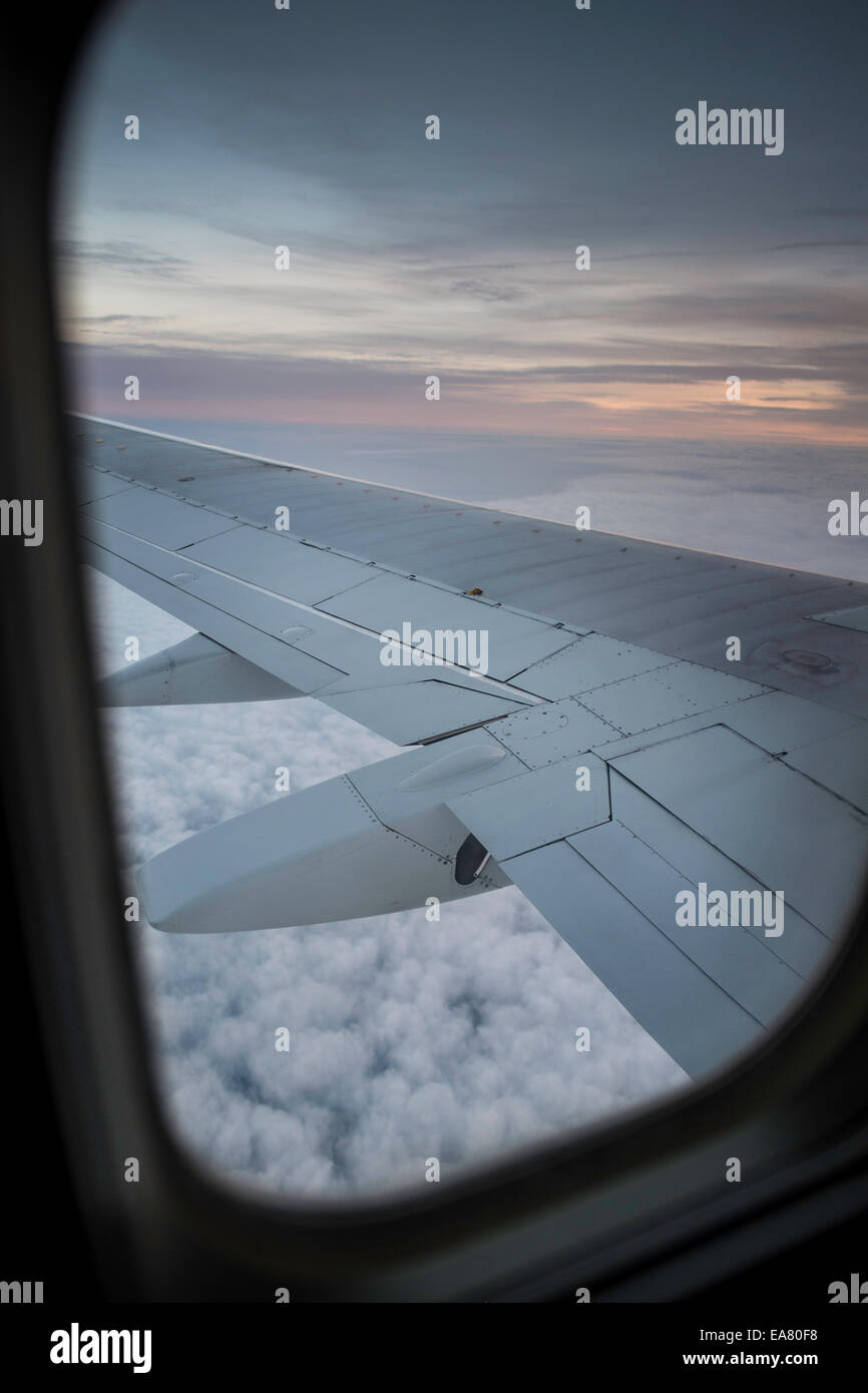 View from window seat, Airplane flying above clouds Stock Photo