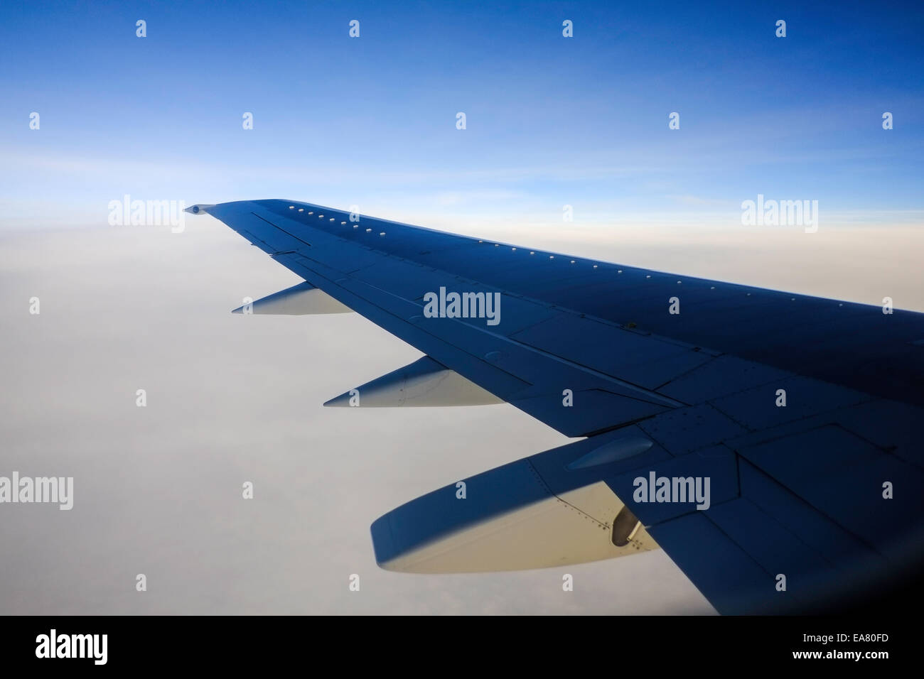 View from window seat, Airplane flying above clouds Stock Photo