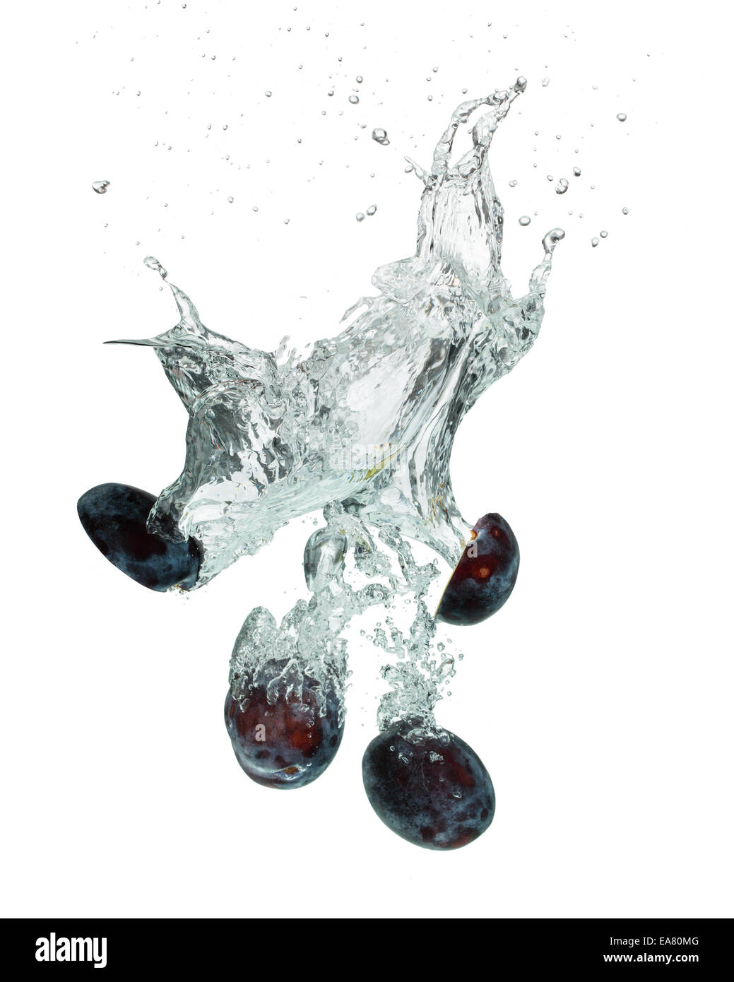 Isolated shot of plums falling into water, isolated on white background