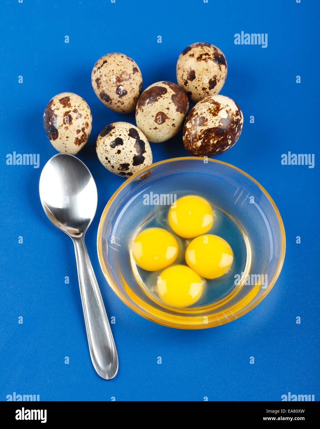Spoon, whole and broken quail eggs in plate Stock Photo Alamy
