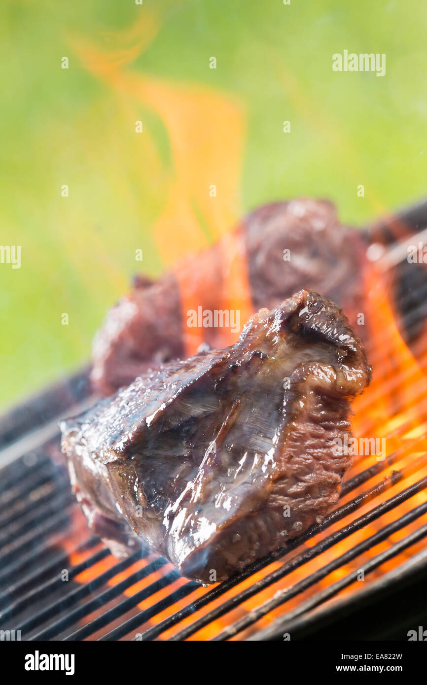 Delicious grilled beef steaks burning on fire Stock Photo Alamy
