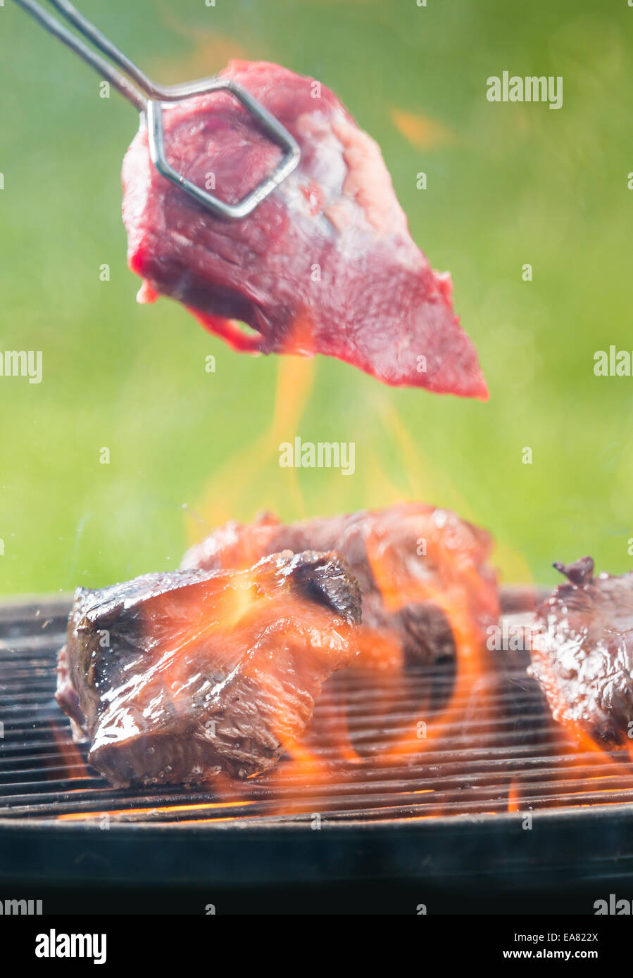 Delicious grilled beef steaks burning on fire Stock Photo Alamy