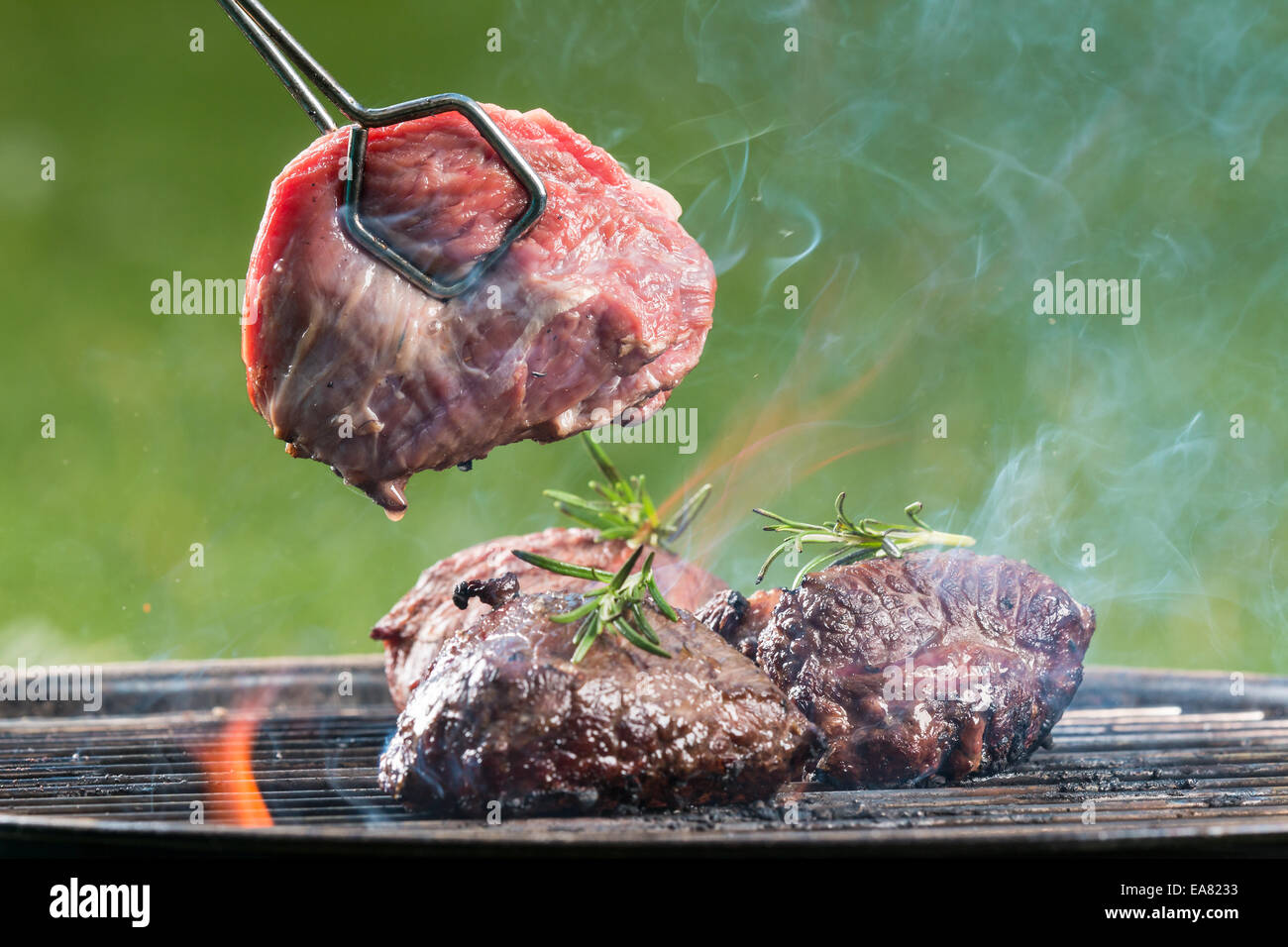 Delicious grilled beef steaks burning on fire Stock Photo Alamy
