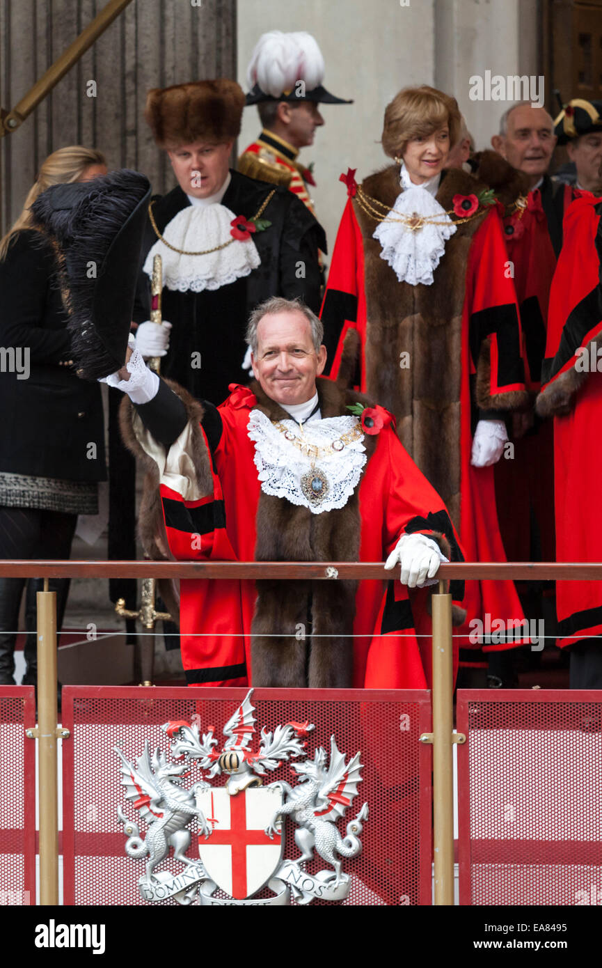 8th November 2014, Lord Mayor's Show, City of London, London, UK. The new 687th Lord Mayor, Alan Yarrow, waves to members of the public from Mansion House balcony at the start of the procession. The outgoing mayor, Fiona Woolf, CBE stands behind him (top right). The Lord Mayor's Show is the oldest civil procession in the world, it celebrates the start of a one-year term for the new Mayor of the City of London. Stock Photo
