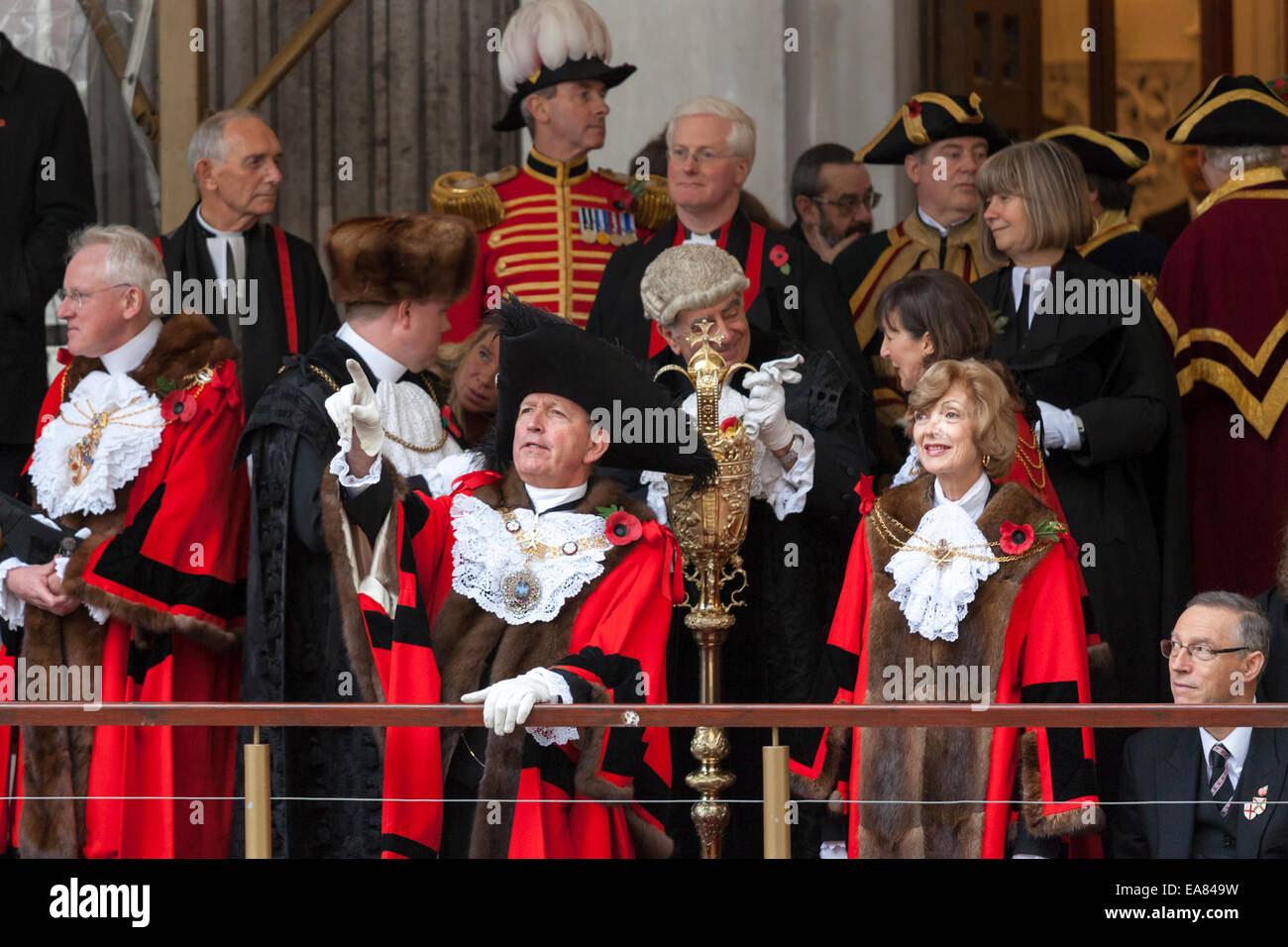 8th November 2014, Lord Mayor's Show, City of London, London, UK. The new 687th Lord Mayor, Alan Yarrow (front middle), watches the procession from Mansion House balcony. The outgoing mayor, Fiona Woolf, CBE stands to his right. The Lord Mayor's Show is the oldest civil processsion in the world, it celebrates the start of a one-year term for the new Mayor of the city of London Stock Photo