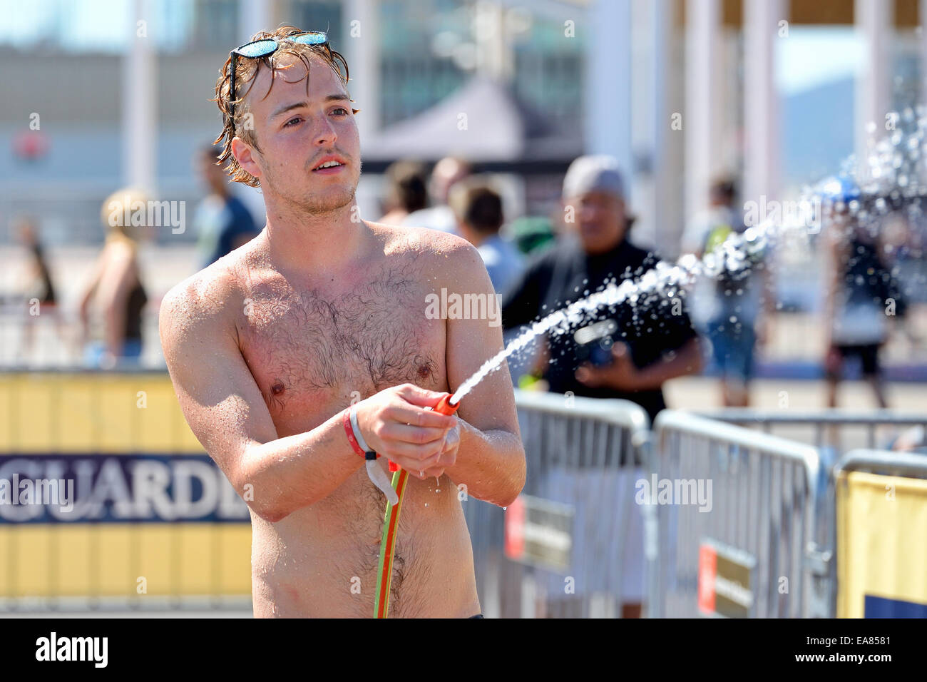 BARCELONA - JUN 29: A man using a hose to wet the audience in a summer day at LKXA Extreme Sports Barcelona Games. Stock Photo