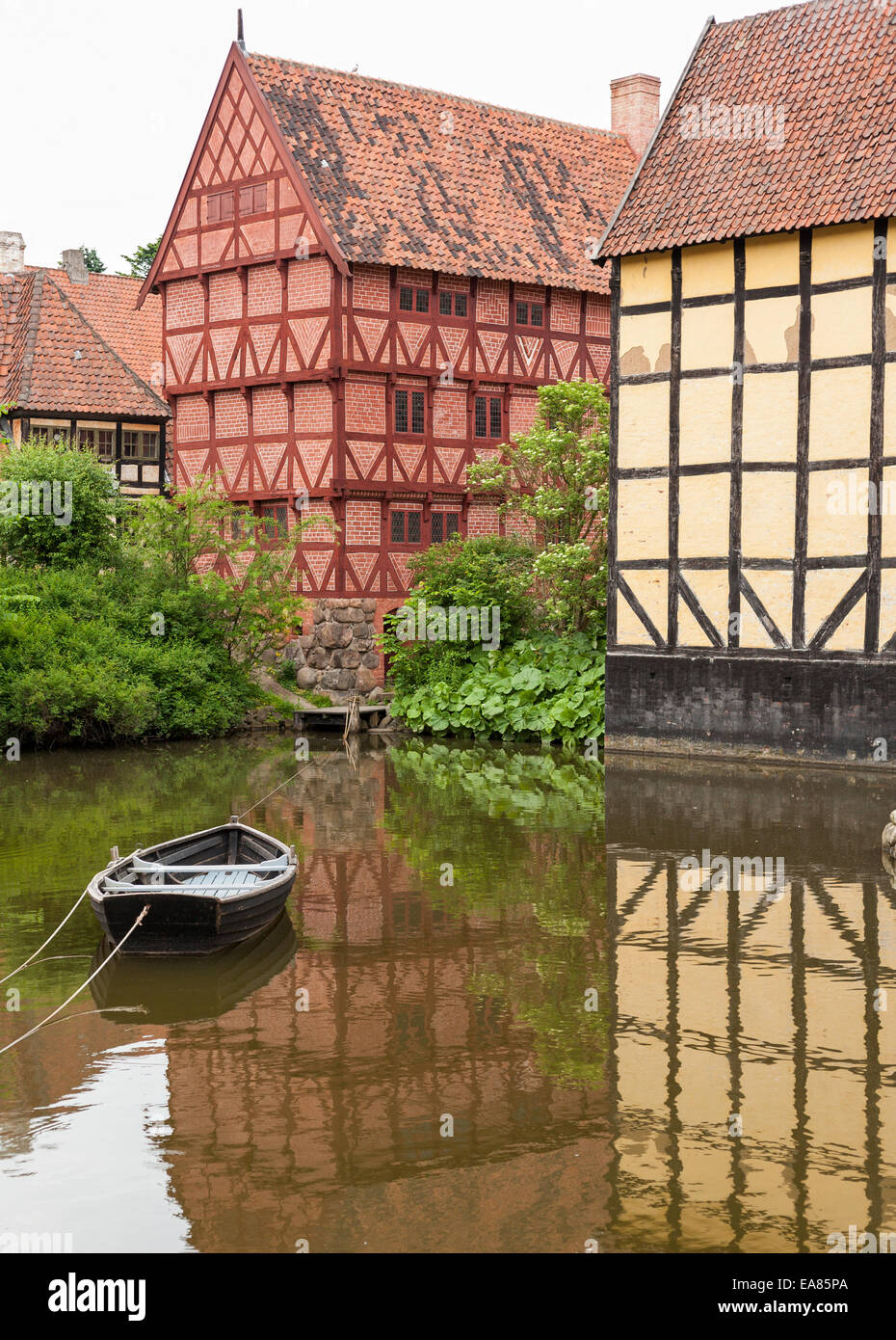 Half Timbered houses of old Aarhus. A small row boat is anchored in the calm water in front of traditional Danish river houses Stock Photo