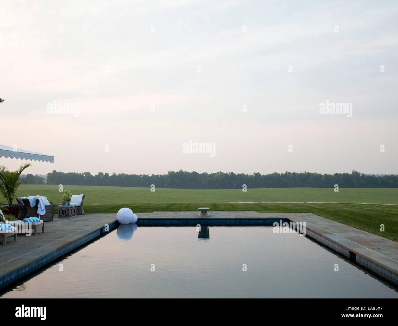 deserted swimming pool at sunrise at country estate Stock Photo